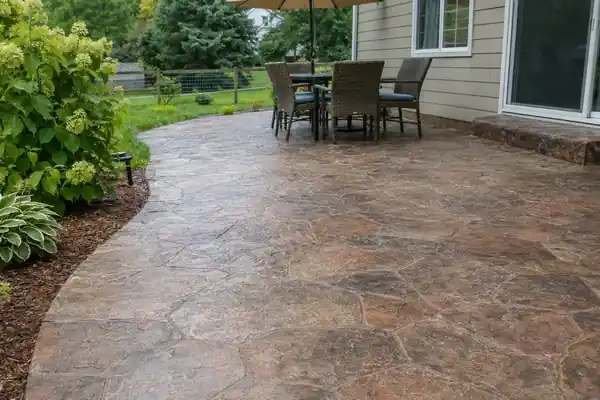 Stamped concrete patio path leading to a table and chairs