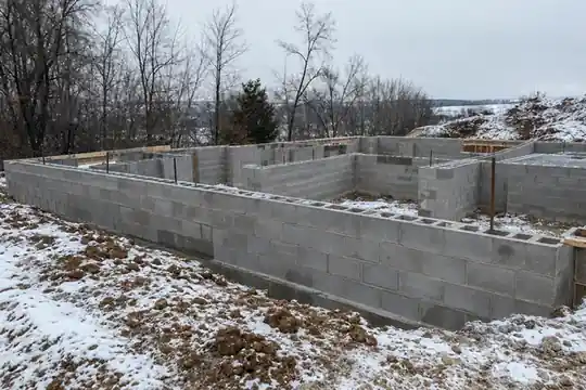 Block foundation walls on a snowy lot